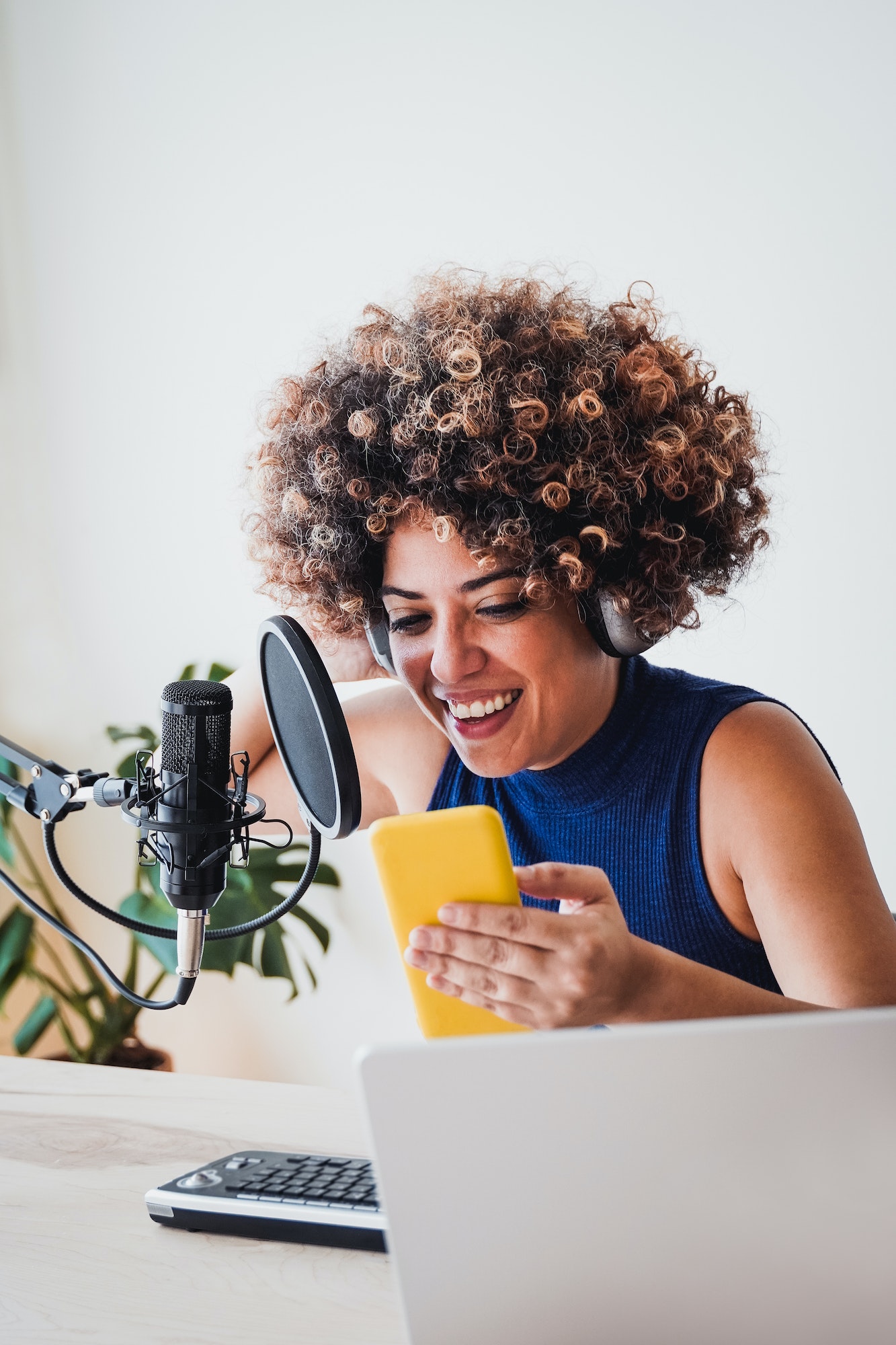 African host woman recording podcast using mobile phone at home studio - Business, podcaster tech